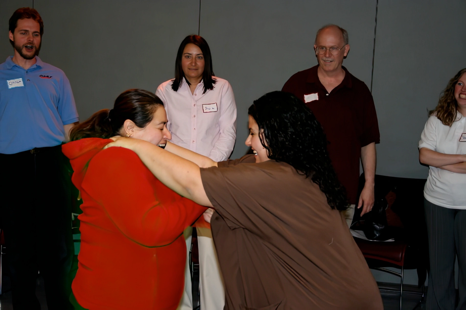Participants practicing a defensive escape technique with instructors observing